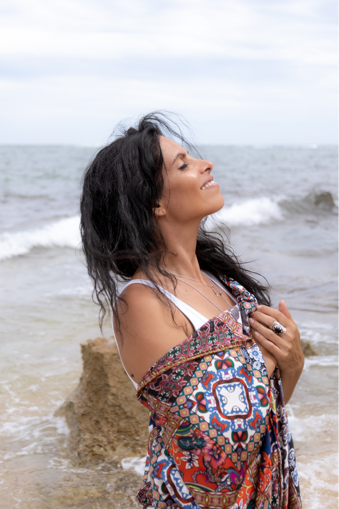 Veronica Galipo, life coach and self-love guide, is enjoying the sun and breeze at the beach.
