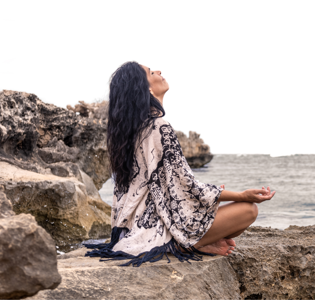 Veronica Galipo, life coach and self-love guide, meditating peacefully by the ocean.