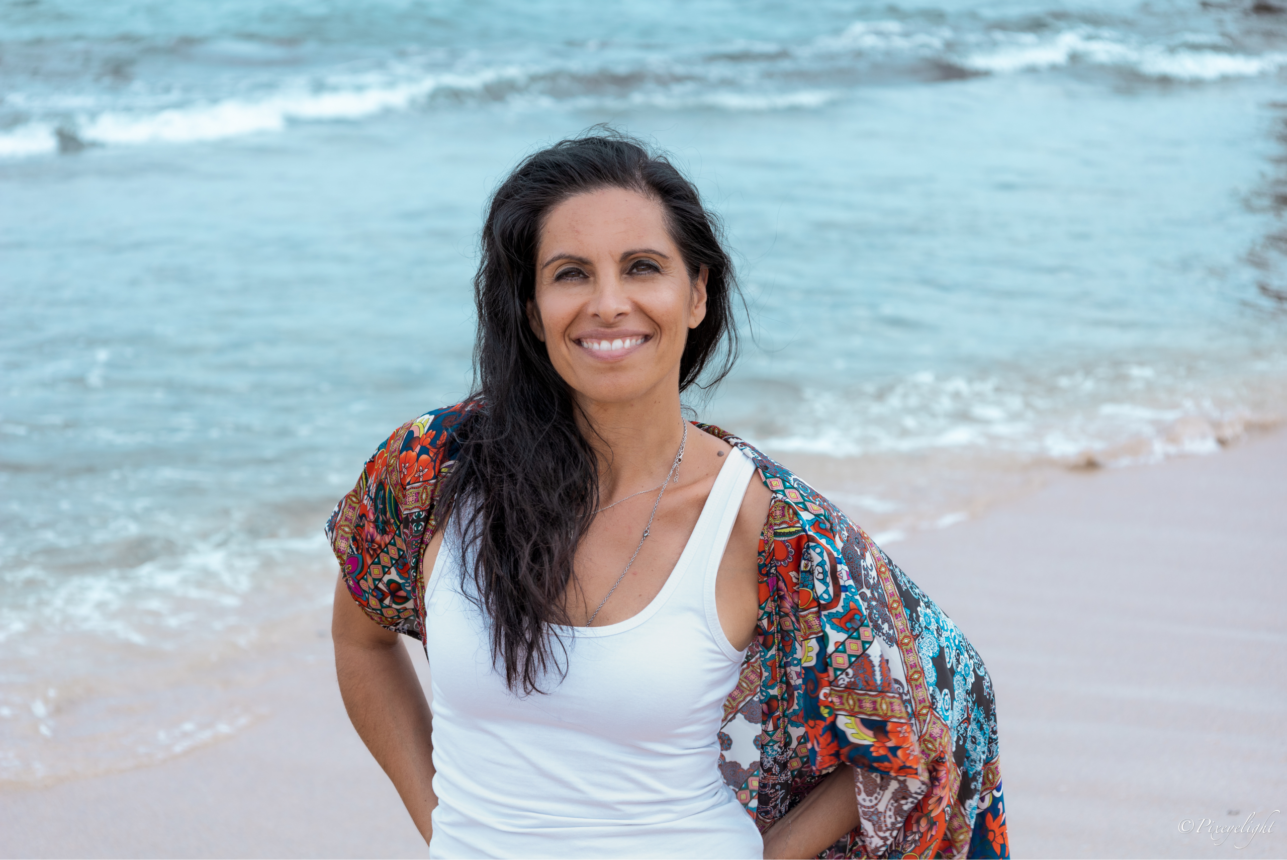 Veronica Galipo, life coach and self-love guide, smiling at the beach in a video welcoming women who feel strong but exhausted.