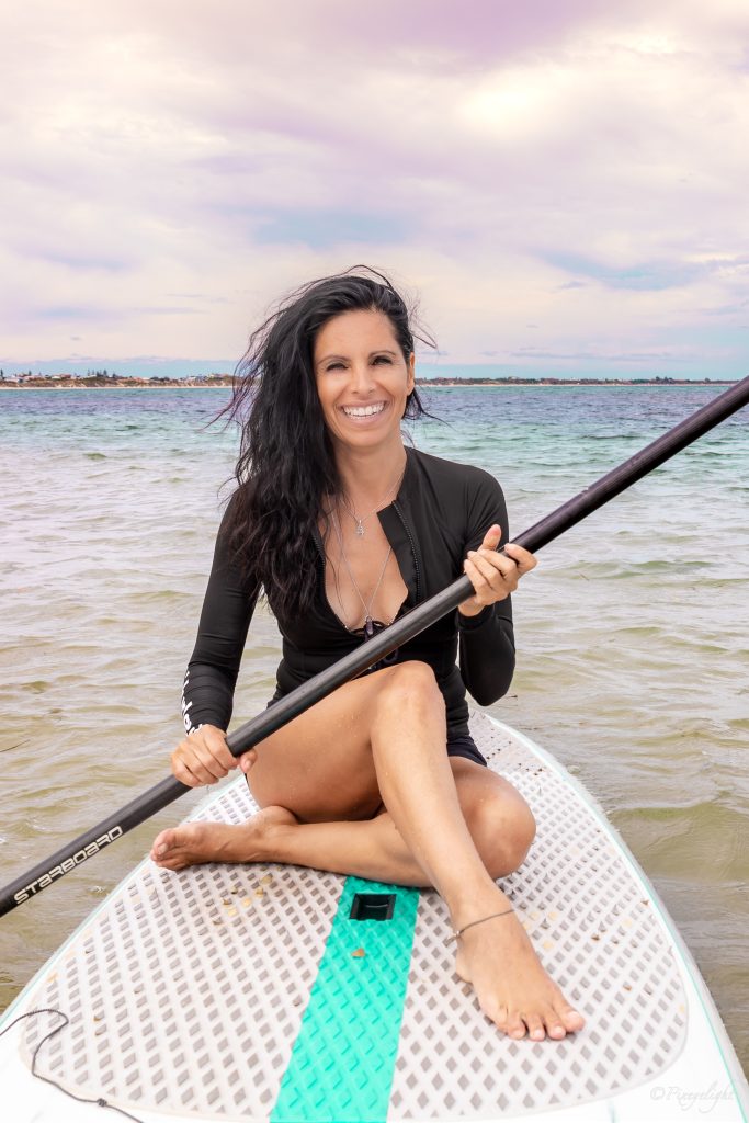 Veronica Galipo, life coach and self-love guide, Stand Up Paddling (SUP) on the water.